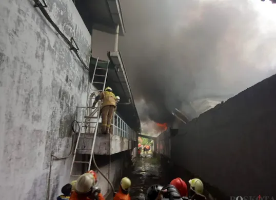 Petugas berusaha memadamkan api saat kebakaran terjadi di gudang aksesoris mobil, Jalan Mangga Ubi RT 06 RW 07, Kecamatan Cengkareng, Jakarta Barat, Kamis, 2 Oktober 2025. (Sumber: POSKOTA | Foto: Pandi Ramedhan)
