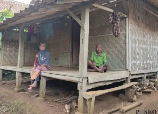 Sepasang kakek-nenek di Kampung Sindanghayu, Desa Tanagara, Kecamatan Cadasari, Kabupaten Pandeglang, duduk di depan rumah mereka. (Sumber: Poskota/Samsul Fatoni)