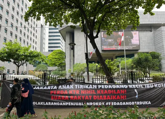 Spanduk penolakan terhadap finalisaai Raperda KTR dibentangkan pedagang di kantor DPRD Jakarta, Jumat, 3 Oktober 2025. (Sumber: Poskota/Pandi Ramedhan)