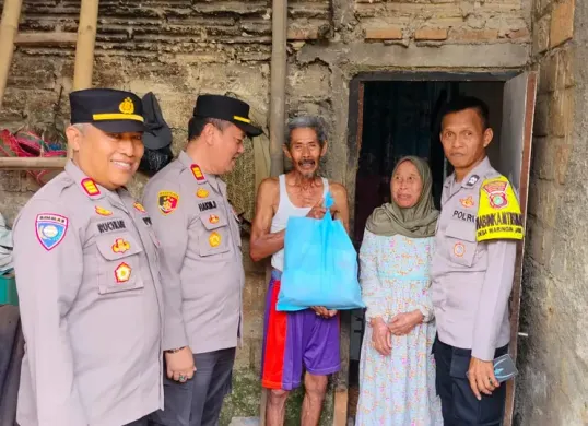 Polisi membagikan paket sembako dalam program Jumat Sodahqoh kepada keluarga Maja di rumahnya Desa Kedung Waringun, Kecamatan Bojonggede, Kabupaten Bogor. (Sumber: Poskota/Angga Pahlevi)