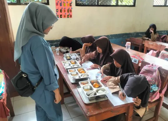 Ahli gizi MBG dari SPPG Pagelaran Sindanglaya 2 saat melakukan uji organoleptik di SDN Senangsari, Kecamatan Pagelaran, Pandeglang. (Sumber: Istimewa)
