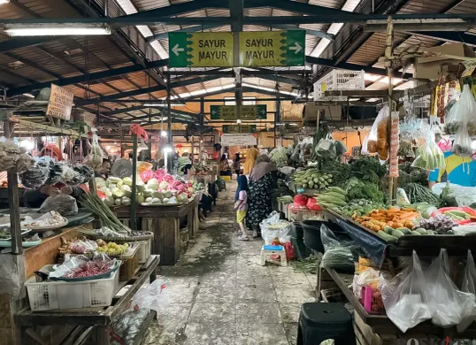 Pedagang sayur di Pasar Embrio, Jakarta Timur, menunggu pembeli di tengah turunnya harga bahan pokok namun pasar masih sepi, Jumat, 10 Oktober 2025. (Sumber: Dhiya Ahmad)