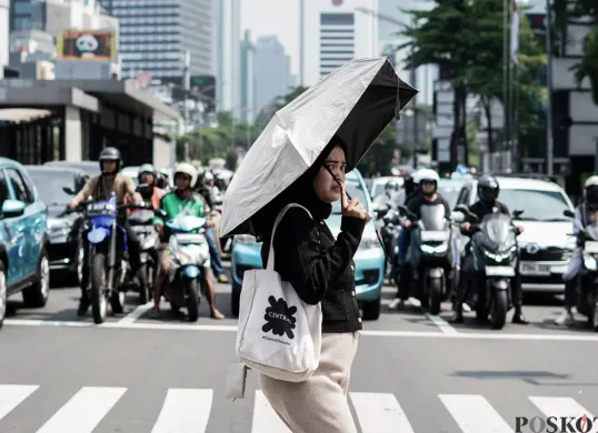 Warga menyeberang jalan saat panas terik matahari di Jalan Jenderal Sudirman, Jakarta Pusat, Kamis, 16 Oktober 2025. (Sumber: Poskota/Bilal Nugraha Ginanjar)