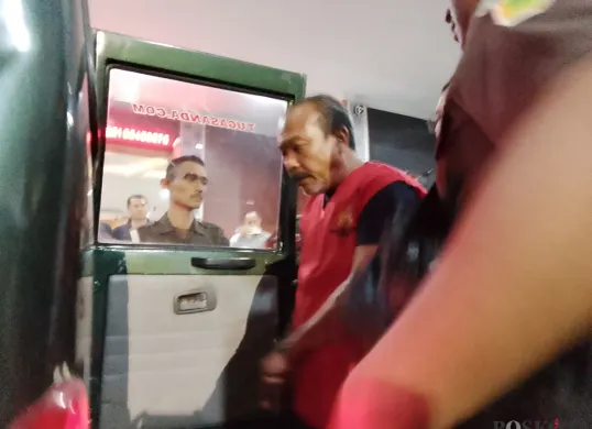 Pelaku penipuan rekrutmen pegawai kejaksaan saat dimasukan ke dalam mobil tahanan Kejari Cimahi. (Sumber: Poskota/Gatot Poedji Utomo)