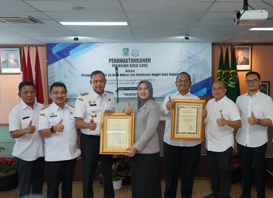 Kepala Kejaksaan Negeri (Kajari) Kota Bekasi Sulvia Triana Hapsari, menerima langsung penghargaan dalam bidang pencapaian pemulihan khas daerah dan pemenangan sengketa lahan dari Wali Kota Bekasi Tri Adhianto. (Sumber: Humas Kejari Kota Bekasi)