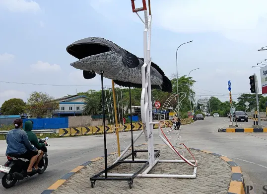 Penampakan patung ikan gabus yang berdiri di depan exit Tol Gabus, Desa Srijaya, Kecamatan Tambun Utara, Kabupaten Bekasi. (Sumber: POSKOTA | Foto: Nurpini Aulia Rapika)