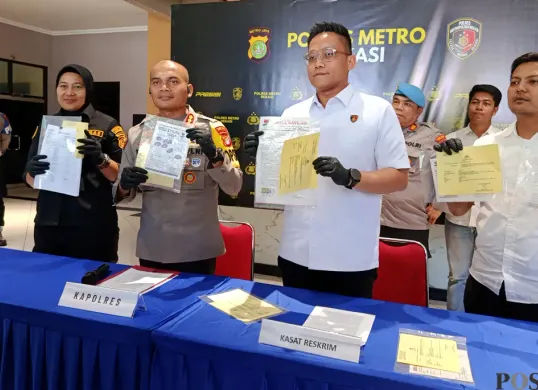 Kapolres Metro Bekasi, Kombes Pol Mustofa menunjukkan barang bukti kasus penipuan dan penggelapan penjualan tanah kavling. (Sumber: POSKOTA | Foto: Nurpini Aulia Rapika)