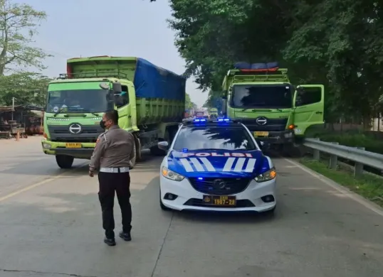 Petugas kepolisian menghadang kendaraan angkutan tambang yang beroperasi di luar jam operasional di wilayah Kabupaten Serang. (Sumber: Dok. Polres Serang)