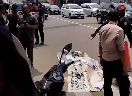 Warga menutup korban meninggal yang terlindas truk di Jalan Cileungsi-Jonggol. (Sumber: Istimewa)