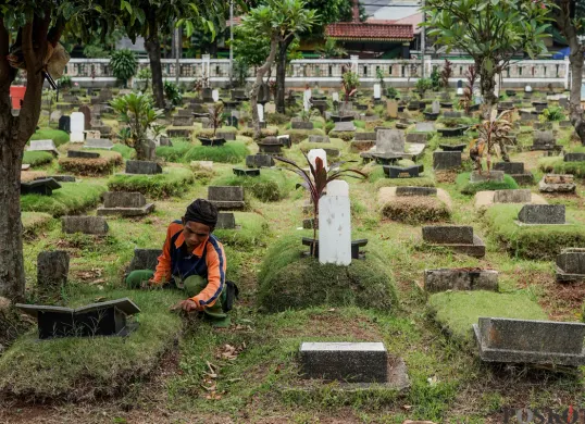 Petugas Suku Dinas Pertamanan dan Hutan Jakarta Selatan membersihkan salah satu makam di Tempat Pemakaman Umum (TPU) Grogol Selatan, Jakarta, Selasa, 21 Oktober 2025. (Sumber: Poskota/Bilal Nugraha Ginanjar)