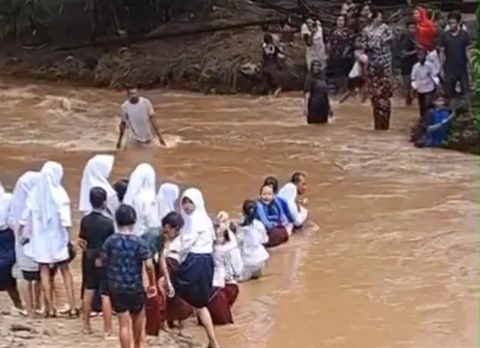 Tangkap layar sejumlah siswa SD dan SMP di Kampung Cegog, Desa Rancapinang, Kecamatan Cimanggu, Kabupaten Pandeglang, saat menyeberang sungai menuju sekolah.