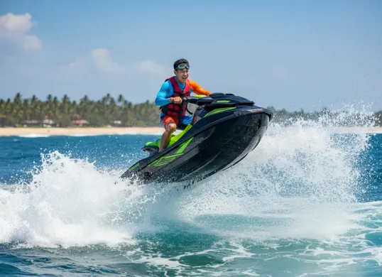 Hasil edit prompt Gemini AI foto cowok keren di pantai sambil bermain jetski. (Sumber: Freepik/pressfoto)