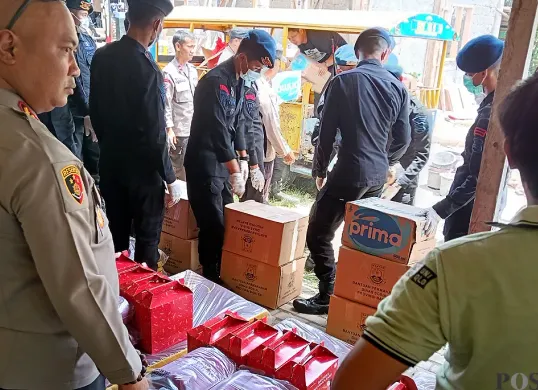 Kapolres Serang AKBP Condro Sasongko (kiri) memantau barang kebutuhan sebelum dibagikan kepada warga yang direlokasi. (Sumber: POSKOTA | Foto: Rahmat Haryono)