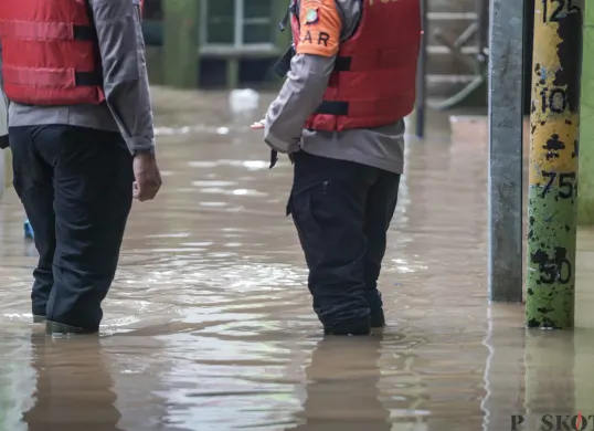 Ilustrasi, warga berjalan melintasi banjir di Kebon Pala, Jatinegara, Jakarta Timur. (Sumber: Poskota/Bilal Nugraha Ginanjar)