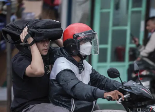 Pengendara sepeda motor menerobos hujan di Jalan Bang Pitung, Kebon Jeruk Jakarta Barat, Kamis, 30 Oktober 2025. (Sumber: Poskota/Bilal Nugraha Ginanjar)