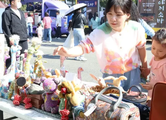Pengunjung asal Korea Selatan antusias melihat dan memilih produk craft boneka batik karya UMKM binaan PLN UID Jakarta Raya di ajang Migran Arirang Multicultural Festival  (MAMF) 24 - 26 Oktober 2025 di Changwon, Korea Selatan. (Sumber: Istimewa)
