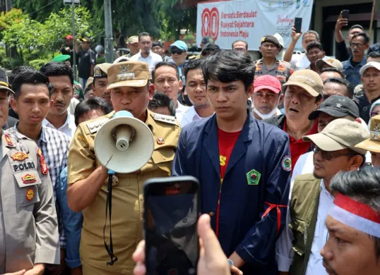 Wali Kota Bekasi, Tri Adhianto sambil memegang pengeras suara menemui massa aksi demo di depan Kantor DPRD Kota Bekasi, Senin 1 September 2025. (Sumber: Dok Humas Pemkot Bekasi)