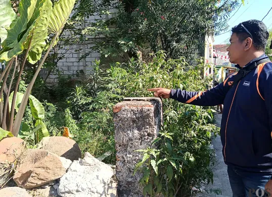 Warga menunjukkan lokasi ditemukannya jasad bayi terbungkus plastik hitam di area makam keluarga, Jalan Sarbini, Kelurahan Jakasampurna, Kota Bekasi, Selasa, 2 September 2025. (Sumber: POSKOTA | Foto: Nurpini Aulia Rapika)