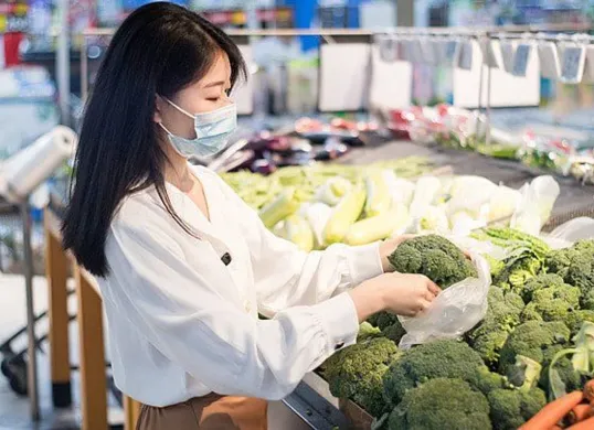 Seorang ibu tengah memilih sayuran di pasar tradisional dengan cermat. (Sumber: Pinterest)