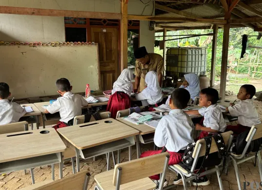 Siswa sekolah SDN Tegal Benteng, Kecamatan Cariu, Kabupaten Bogor, terpaksa belajar di halaman rumah warga karena bangunan kelas sedang diperbaiki akibat rusak parah. (Sumber: Poskota/Giffar Rivana)