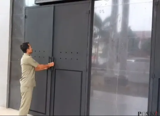 Salah seorang petugas Satpol PP saat memperlihatkan pintu baja di depan Kantor Bupati Pandeglang. (Sumber: Poskota/Samsul Fatoni)