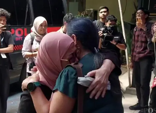 Magda Antista (berkerudung pink), ibu dari Delpedro Marhaen, menangis dipelukan pakar hukum tata negara, Bivitri Susanti saat menjenguk putranya di Polda Metro Jaya, Rabu, 10 September 2025. (Sumber: POSKOTA | Foto: Ali Mansur)