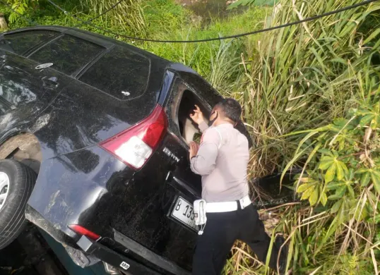 Kanit Lantas Polsek Bojong Sari, Iptu Suwardi saat melakukan olah TKP mobil masuk ke dalam selokan di Jalan Raya Parung-Ciputat, Kota Depok. (Sumber: Dok Polsek Bojongsari)