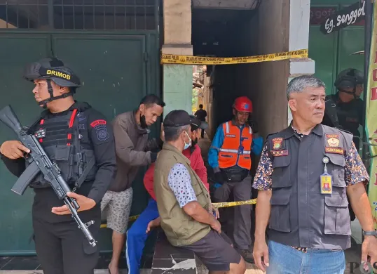 Petugas Brimob dan aparat kepolisian berjaga di lokasi ledakan misterius di Gang Senggol, Pamulang, Tangerang Selatan, Jumat, 12 September 2025.  (Sumber: Poskota/Angga Pahlevi)
