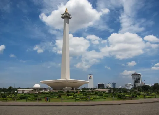 Monumen Nasional (Monas) menjulang megah sebagai ikon Jakarta, dikelilingi taman hijau yang ramai pengunjung. (Sumber: Pinterest)
