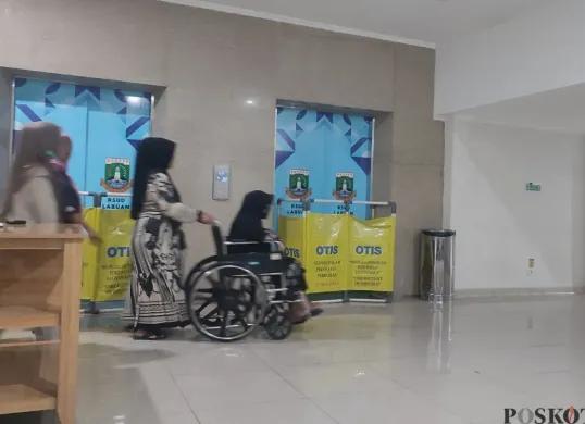 Sejumlah keluarga pasien harus membawa pasien menggunakan kursi roda melalui jalur evakuasi di RSUD Labuan, Kabupaten Pandeglang. (Sumber: Poskota/Samsul Fatoni)