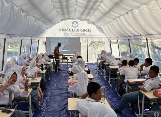 Siswa-siswi SMKN 1 Cileungsi belajar di tenda darurat dan halaman sekolah pasca ambruknya ruang kelas. (Sumber: Poskota/Giffar Rivana)