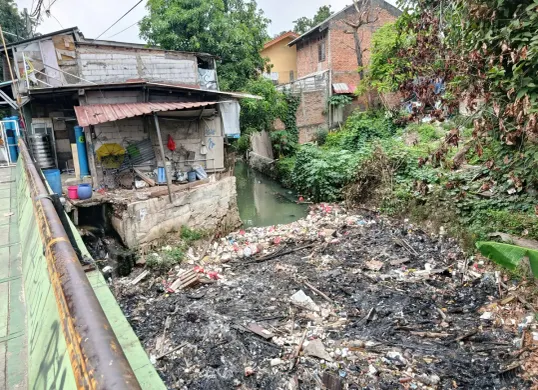 Tumpukan sampah menutupi aliran Kalibaru di Jalan Kalibaru Timur, Medan Satria, Kota Bekasi, Rabu 17 September 2025. Warga khawatir kondisi ini bisa memicu banjir bila tak segera diangkut. (Sumber: Poskota/Nurpini Aulia Rapika)