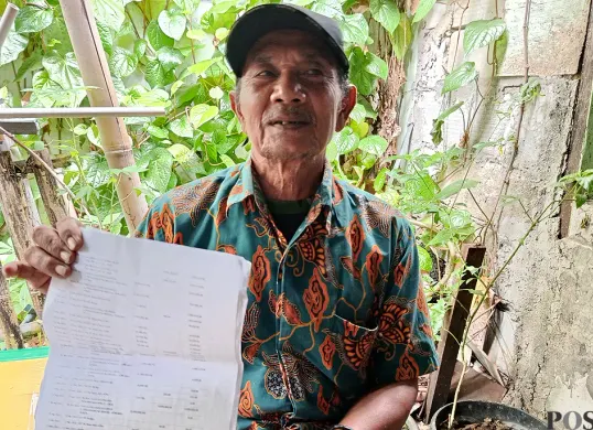 M Husin, petugas keamanan Puskesmas Teluk Pucung, Bekasi Utara, menunjukkan bukti mutasi rekening miliknya kepada awak media pada Kamis, 18 September 2025. (Sumber: POSKOTA | Foto: Nurpini Aulia Rapika)
