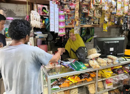 Ilustrasi pedagang warung kelontong di Palmerah, Jakarta Barat, saat sedang melayani pembeli. (Sumber: Poskota/Pandi Ramedhan)