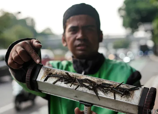 Seorang relawan menunjukkan ranjau paku yang dikumpulkan di sepanjang Jalan Gatot Subroto, Jakarta, Senin, 22 September 2025. (Sumber: POSKOTA | Foto: Bilal Nugraha Ginanjar)