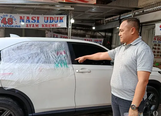 Peter Riano Rissi menunjukkan, kondisi kaca mobilnya yang pecah usai dibobol maling di Jalan Pramuka, Kecamatan Rawalumbu, Kota Bekasi. (Sumber: POSKOTA | Foto: Nurpini Aulia Rapika)