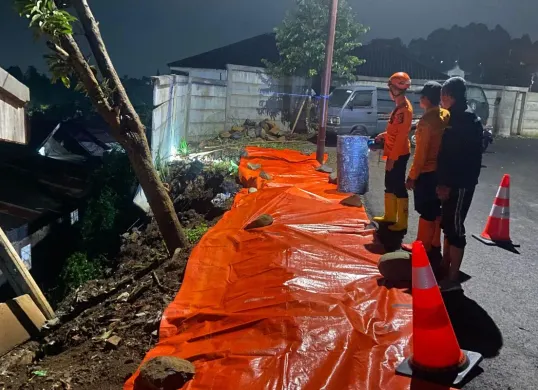Petugas meninjau longsoran TPT di Mako Pusdik Reskrim, Megamendung, Kabupaten Bogor. (Sumber: Dok. BPBD Kabupaten Bogor)