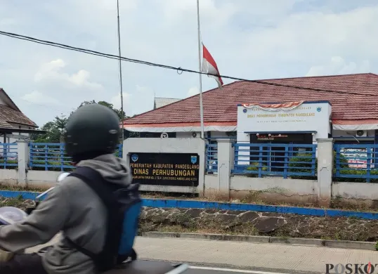 Bendera setengah tiang berkibar di halaman depan Kantor Dishub Kabupaten Pandeglang, Selasa, 30 September 2025. (Sumber: Poskota/Samsul Fatoni)