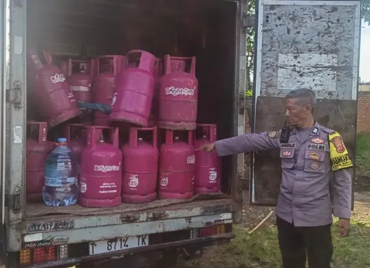 Petugas Polsek Tanjungsari memeriksa mobil box yang berisi ratusan tabung gas 12 kilogram untuk dioplos ke tabung yang lebih kecil di wilayah Desa Tanjungsari, Kabupaten Bogor. (Sumber: Dok. Polsek Tanjungsari)