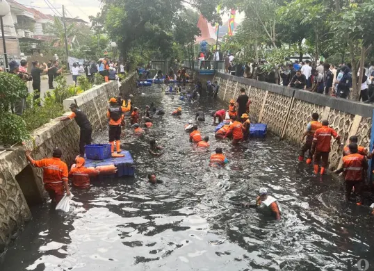 Petugas PPSU memburu ikan sapu-sapu di aliran kali RW 06, Janur Elok VI Blok QD9, Kelapa Gading, Jakarta Utara, Jumat, 17 April 2026. (Sumber: Poskota/M. Tegar Jihad)