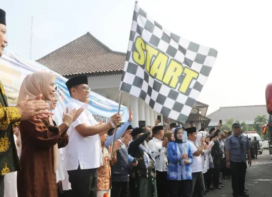 Gubernur Banten, Andra Soni didampingi Bupati Serang Rachmatuzakiyah melepas rombongan haji di halaman pendopo Bupati Serang. (Sumber: Dok. Pemkab Serang)