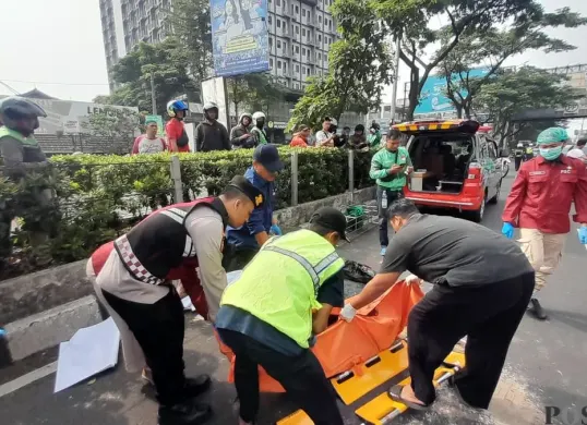 Kompol Daru W Saputro dan petugas evakuasi jenazah korban kecelakaan di Jalan Margonda, Depok, Selasa 28 April 2026. (Sumber: Poskota/Angga Pahlevi)
