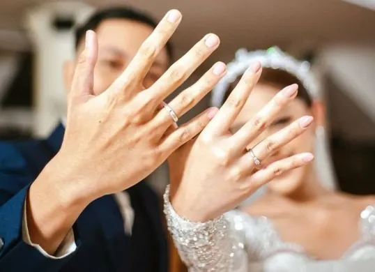 Pasangan pengantin merayakan pernikahan dengan memperlihatkan cincin pernikahan. (Sumber: Pinterest)