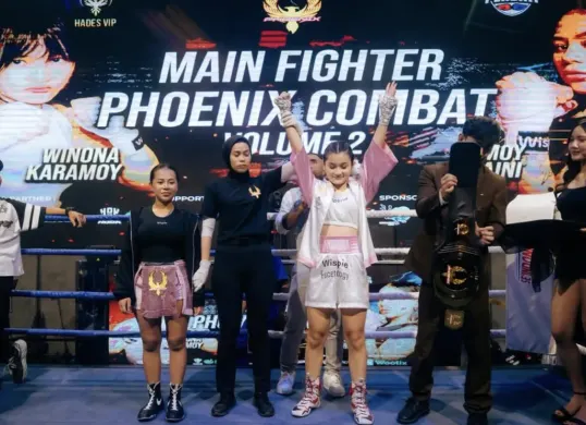 Winona Karamoy mengangkat gelar kemenangan setelah wasit menghentikan pertandingan di Phoenix Combat Sport Vol. 2 (Sumber: Instagram/@winonaaakaramoy)