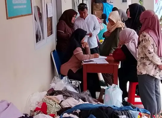 Warga terdampak membawa bantuan berupa pakaian yang disediakan di Kantor Desa Pasirlangu, Bandung Barat, Senin 2 Februari 2026. (Sumber: Poskota/Gatot Poedji Utomo)