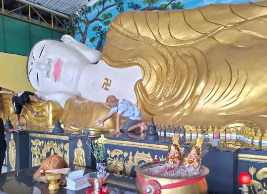 Proses pembersihan patung Buddhan tidur di Vihara Buddha Darma, Kampung Jati RT 002/RW 06, Desa Tonjong, Kecamatan Tajurhalang, Kabupaten Bogor, Rabu, 11 Februari 2026. (Sumber: Poskota/Angga Pahlevi)