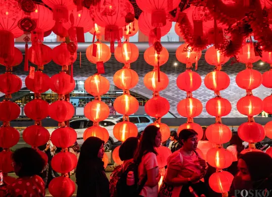 Warga berjalan melewati instalasi Festival Imlek Jakarta di kawasan Bundaran HI, Jakarta, Jumat, 13 Februari 2026. (Sumber: Poskota/Bilal Nugraha Ginanjar)