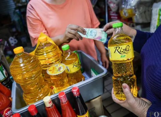 Pedangang menata minyak goreng pada etalase kios miliknya di Pasar Tebet, Jakarta Selatan, Rabu, 18 Februari 2026. (Sumber: Poskota/Bilal Nugraha Ginanjar)