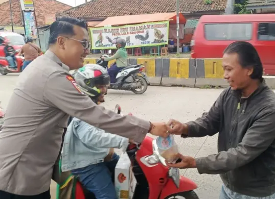 Petugas Polsek Ciruas membagikan takjil kepada pengguna jalan di depan Mako Polsek Ciruas. (Sumber: Dok. Polsek Ciruas)