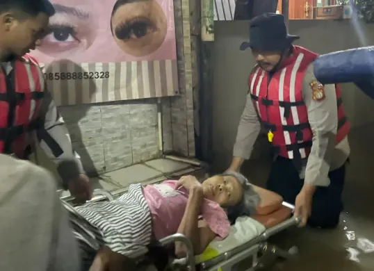 Personel Direktorat Samapta (Ditsamapta) Polda Metro Jaya mengevakuasi seorang warga lanjut usia yang sedang sakit akibat banjir di Jalan Kebon Pala, Kampung Melayu, Jakarta Timur. (Sumber: Polda Metro Jaya)